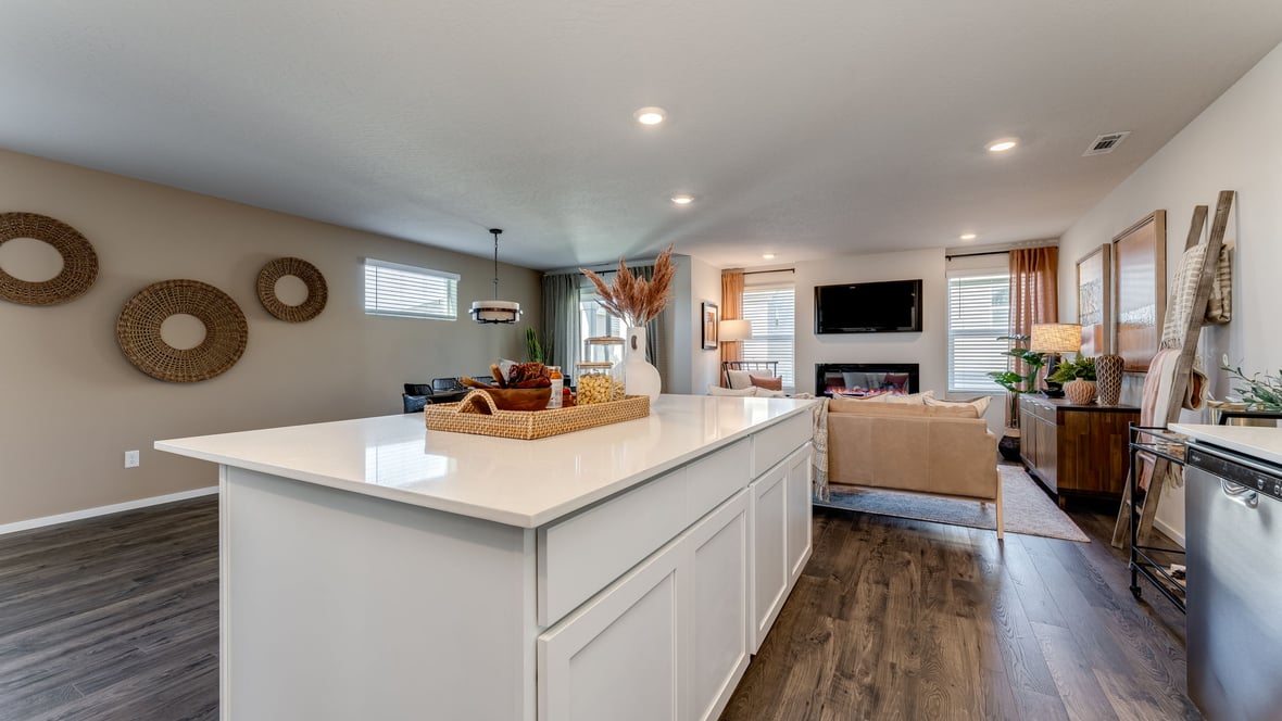 Kitchen with shaker cabinets, quartz counters, stainless steel appliances, pantry, and an island with a breakfast bar