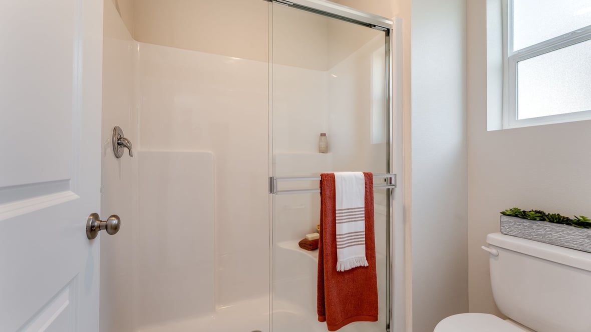 Primary bathroom with quartz counters and a walk-in shower