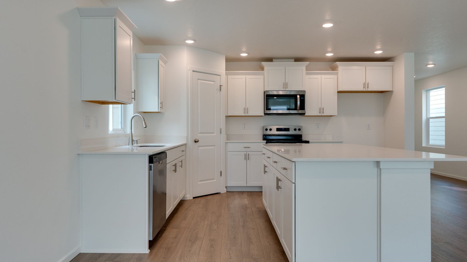Kitchen with shaker cabinets, quartz counters, stainless steel appliances, pantry, and an island with a breakfast bar