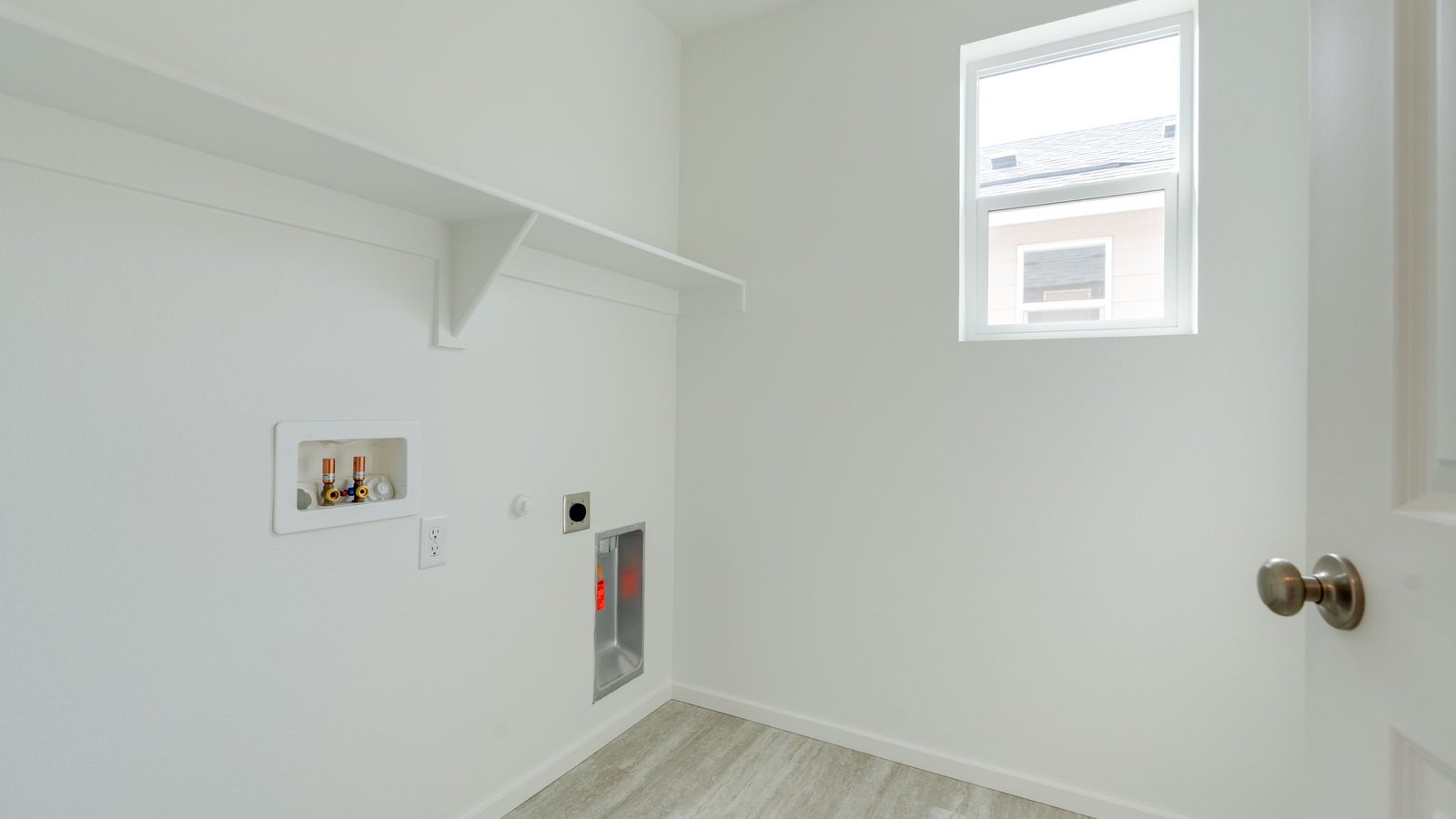 Laundry room with built-in shelves and washer and dryer hookups