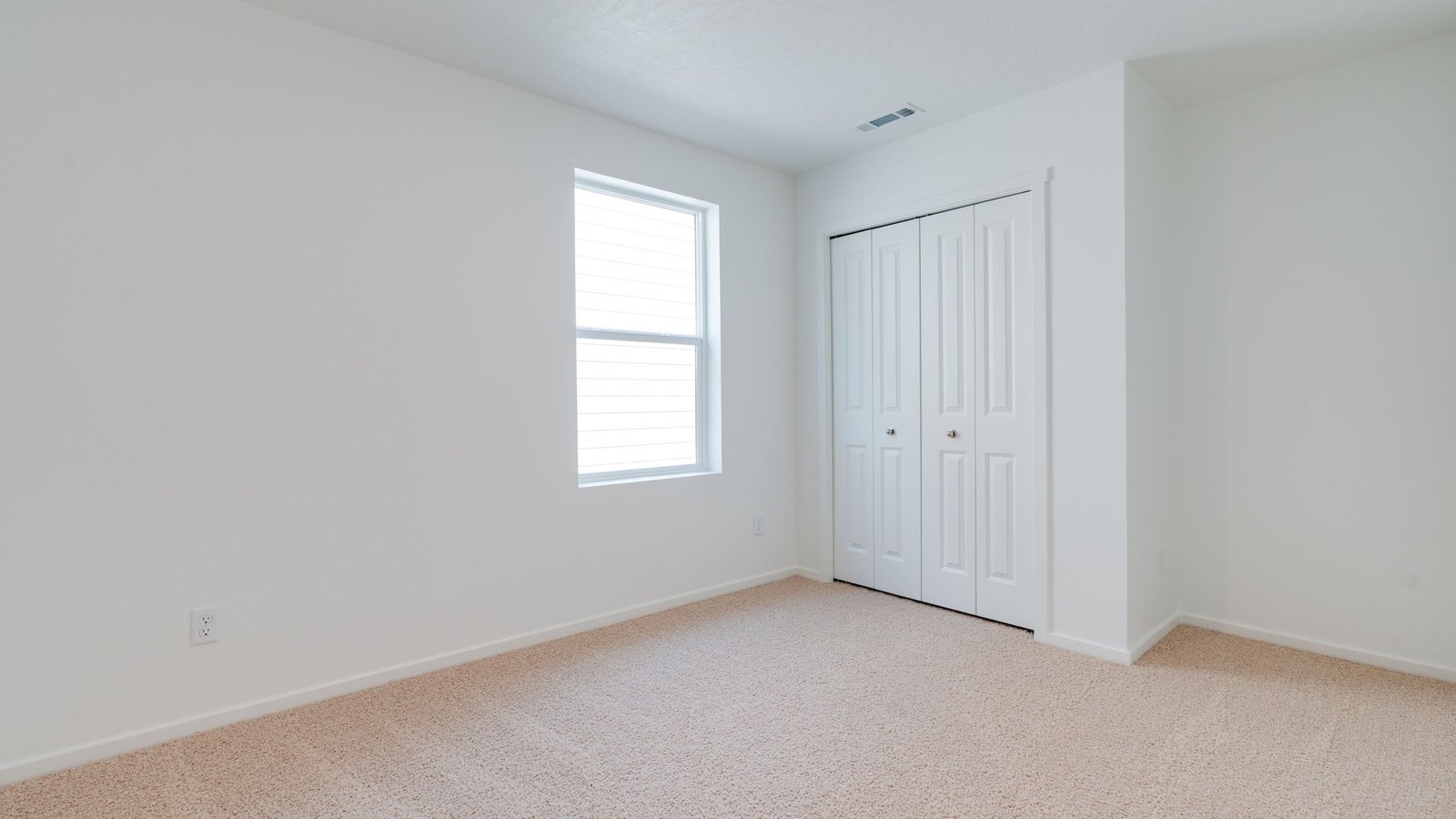 Bedroom with wall-to-wall carpet and a closet