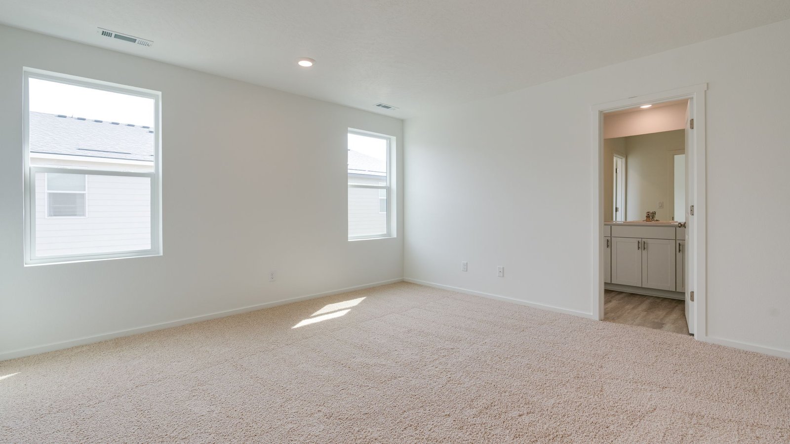 Primary bedroom with wall-to-wall carpet, a walk-in closet and an attached bathroom
