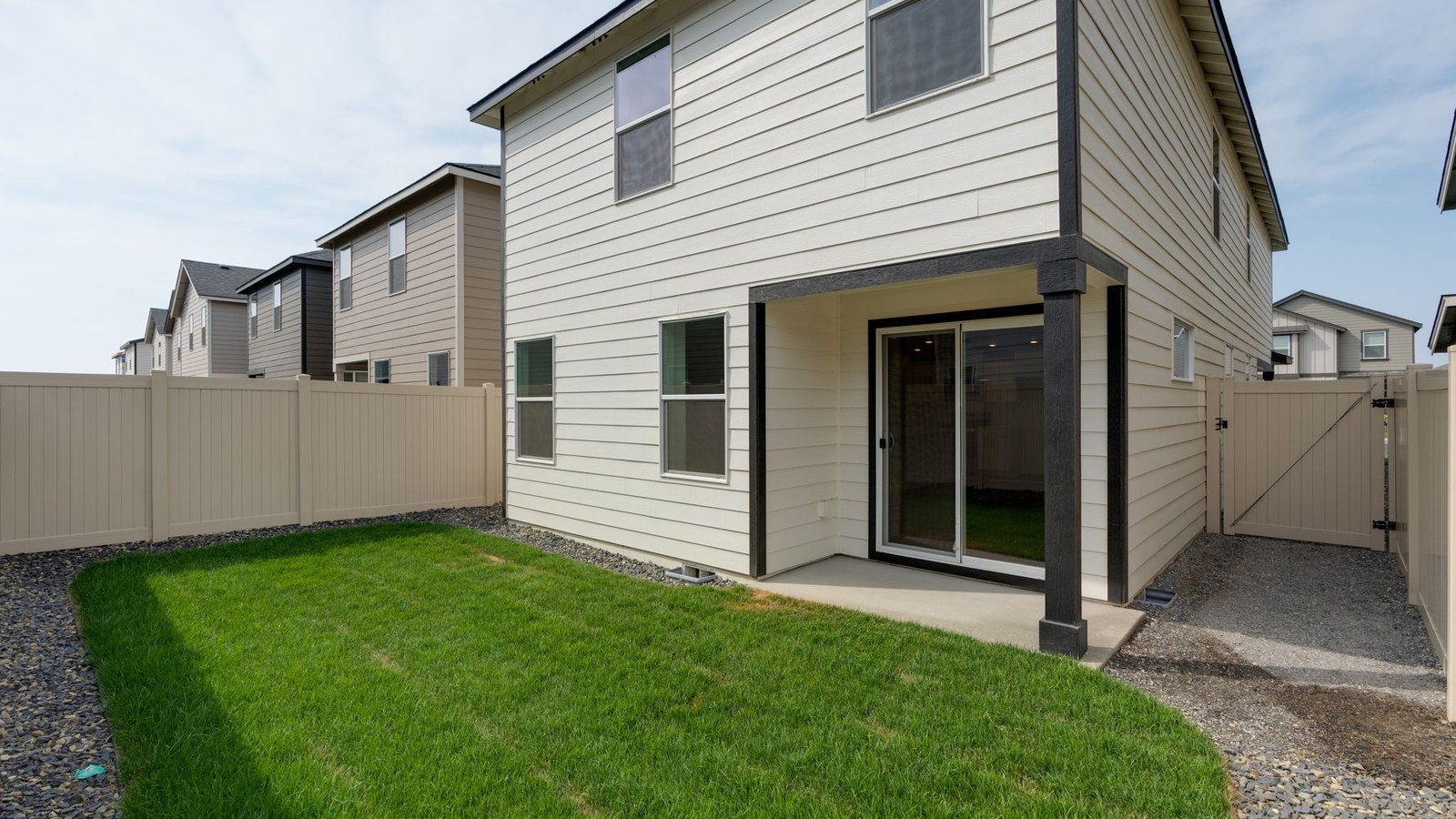 fully fenced backyard with sod lawn and a patio