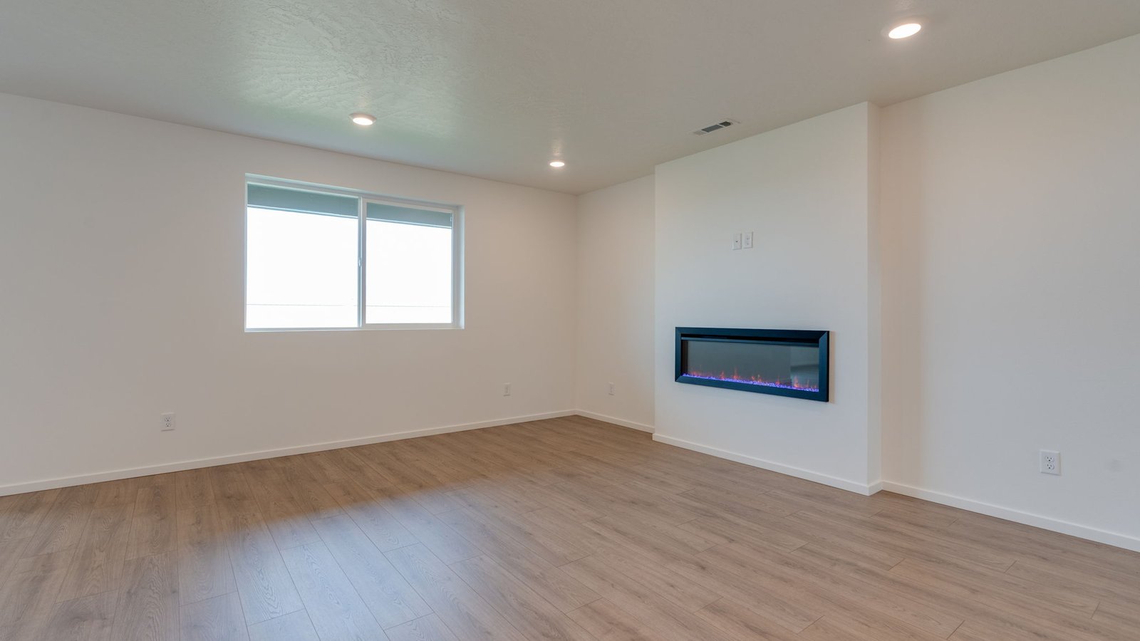 Great room with laminate flooring and an electric fireplace