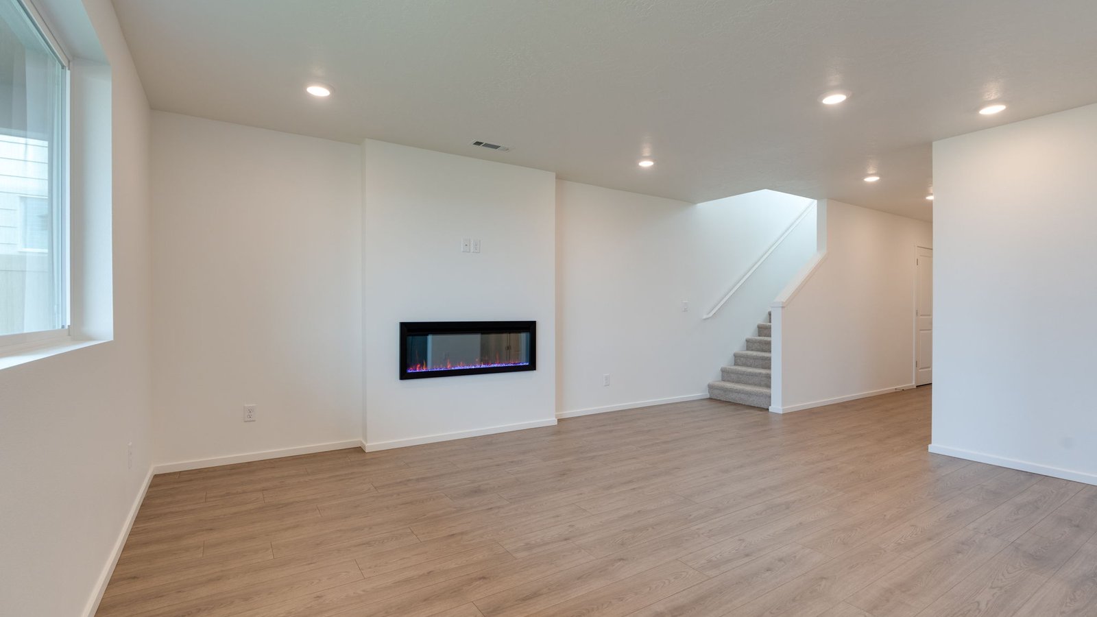 Great room with laminate flooring and an electric fireplace