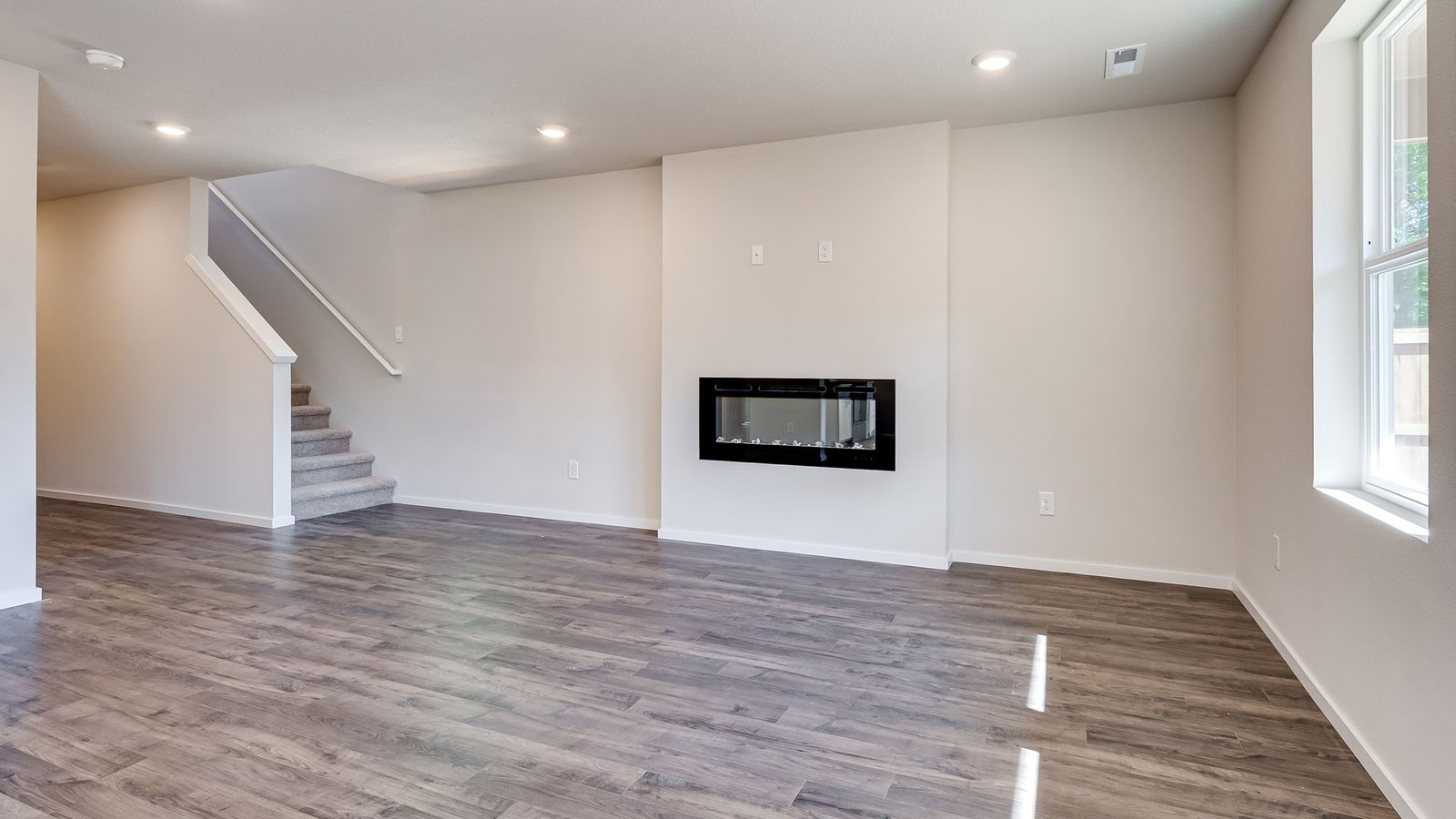 Great room with laminate flooring and an electric fireplace