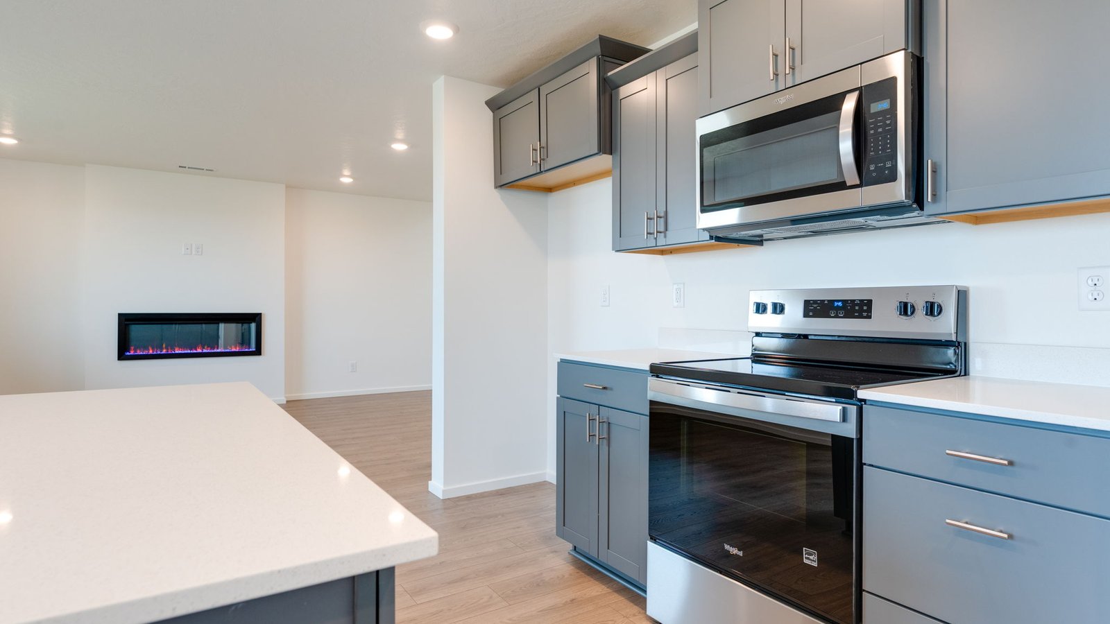 Kitchen with shaker cabinets, quartz counters, stainless steel appliances, pantry, and an island with a breakfast bar