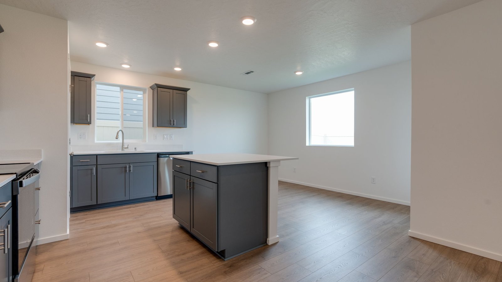 Kitchen with shaker cabinets, quartz counters, stainless steel appliances, pantry, and an island with a breakfast bar