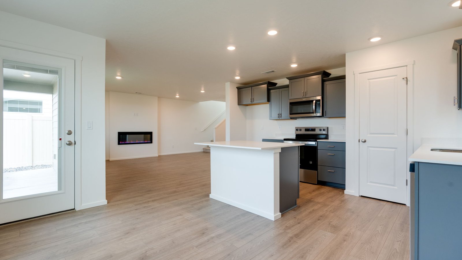 Kitchen with shaker cabinets, quartz counters, stainless steel appliances, pantry, and an island with a breakfast bar