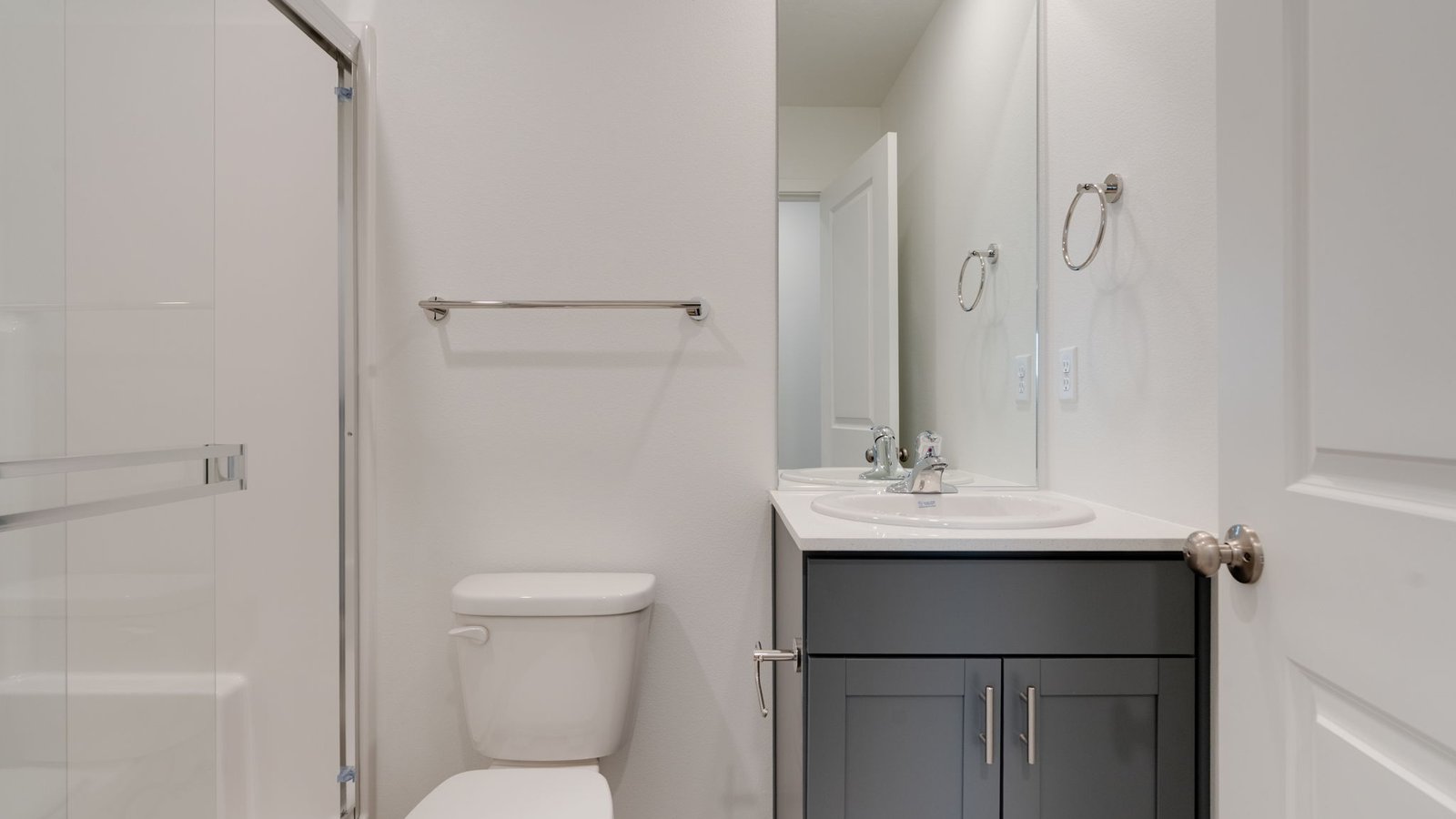 bathroom with quartz counters and a walk-in shower