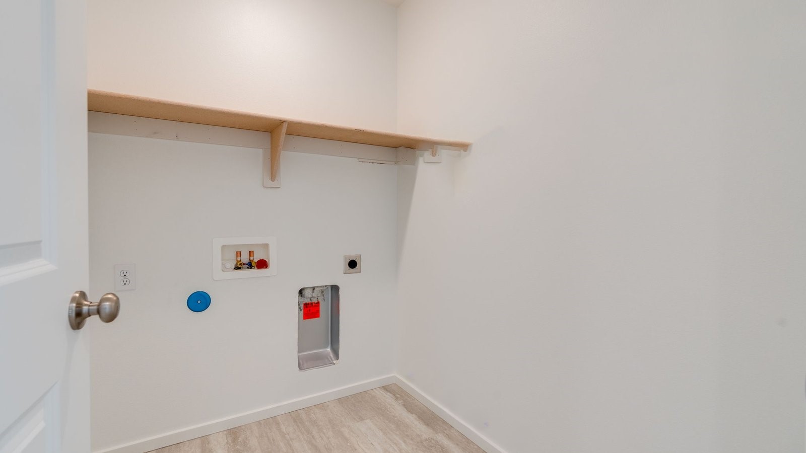 Laundry room with built-in shelves and washer and dryer hookups