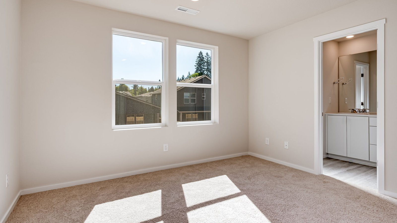 Primary bedroom with wall-to-wall carpet, a walk-in closet and an attached bathroom