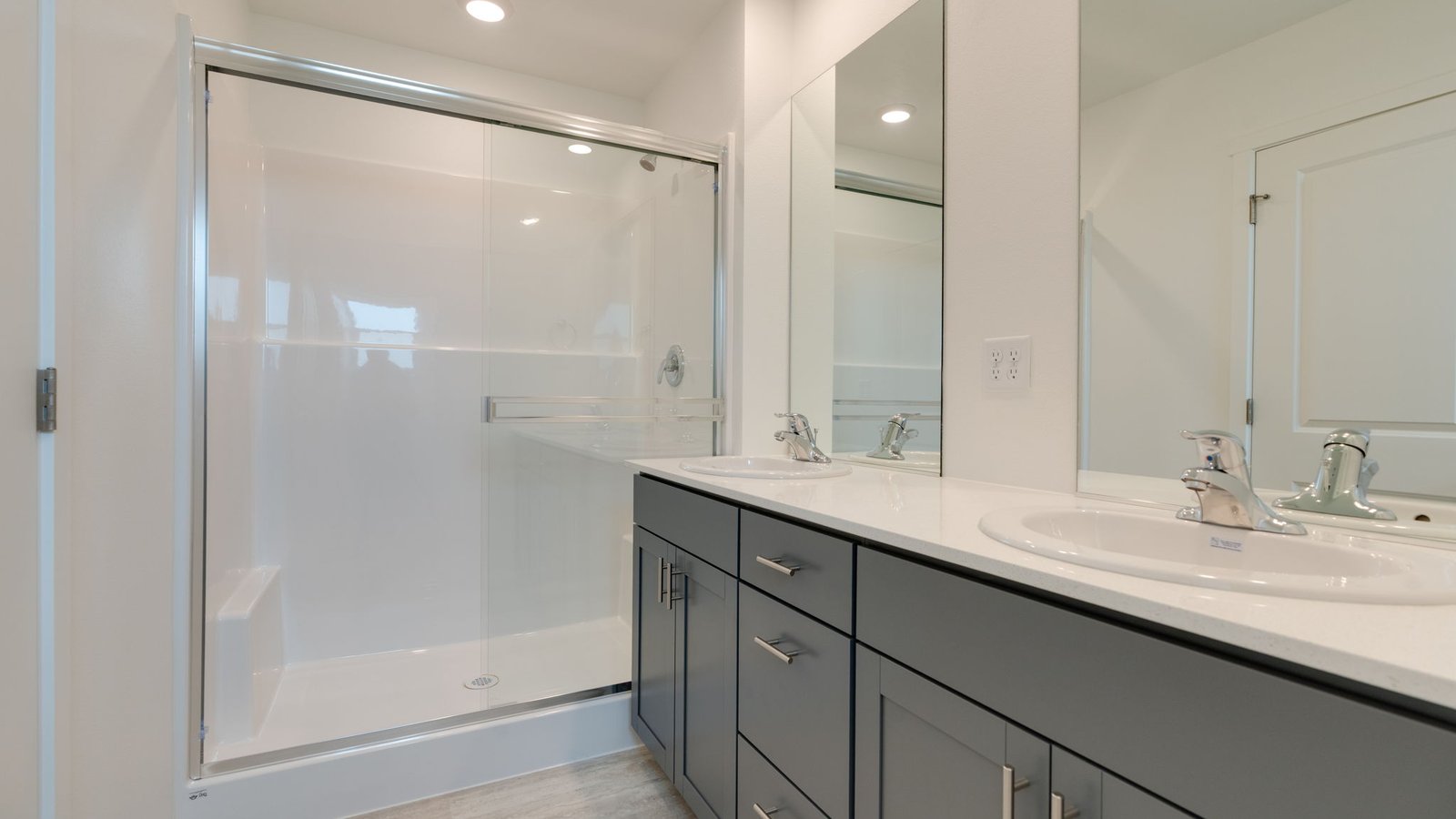 Primary bathroom with quartz counters and a walk-in shower