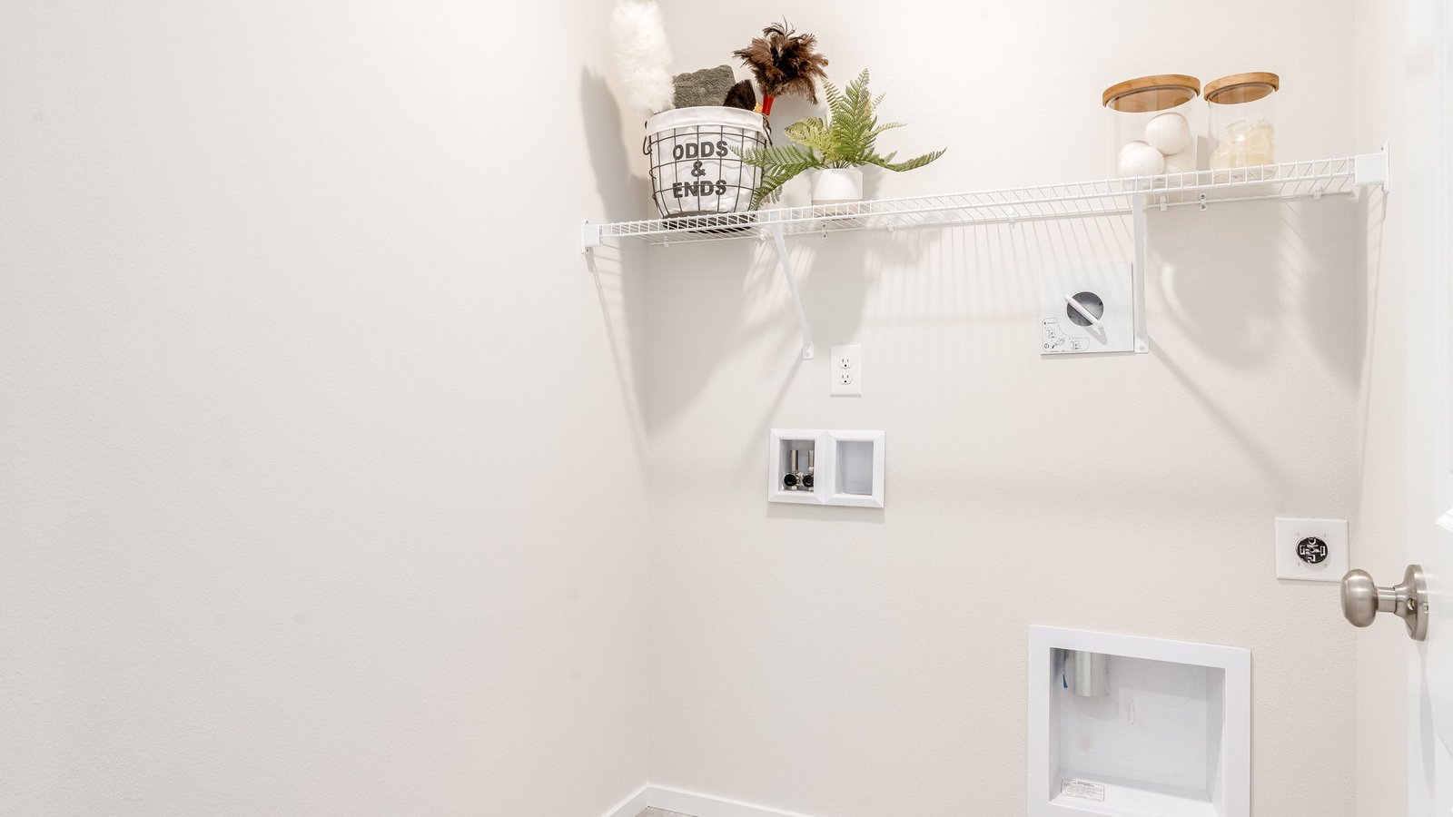 Laundry room with built-in shelves and washer and dryer hookups