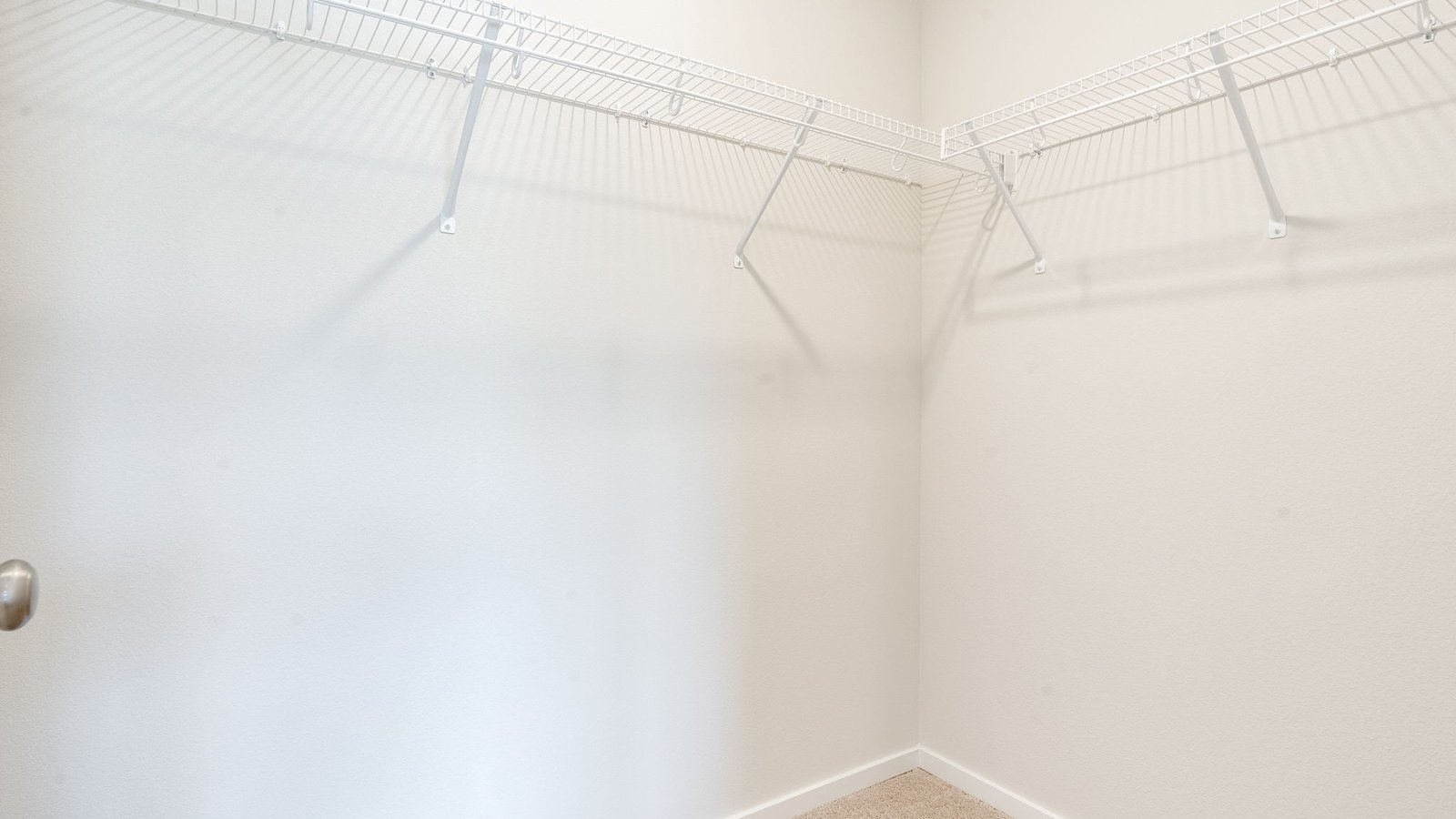 Primary bedroom walk-in closet with built-in shelves