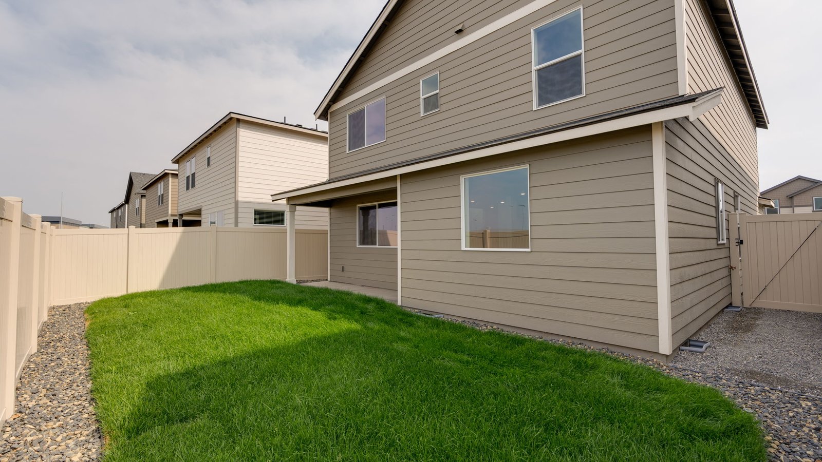 fully fenced backyard with sod lawn and a patio