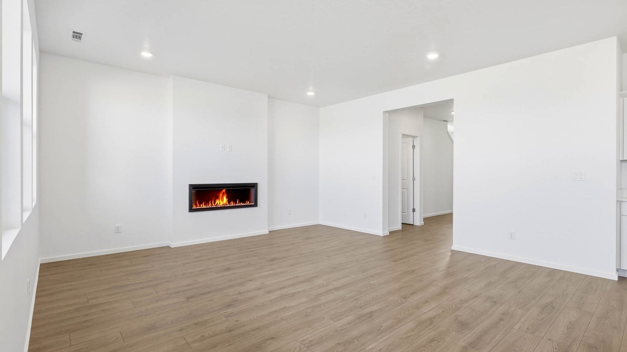Great room with laminate flooring and an electric fireplace