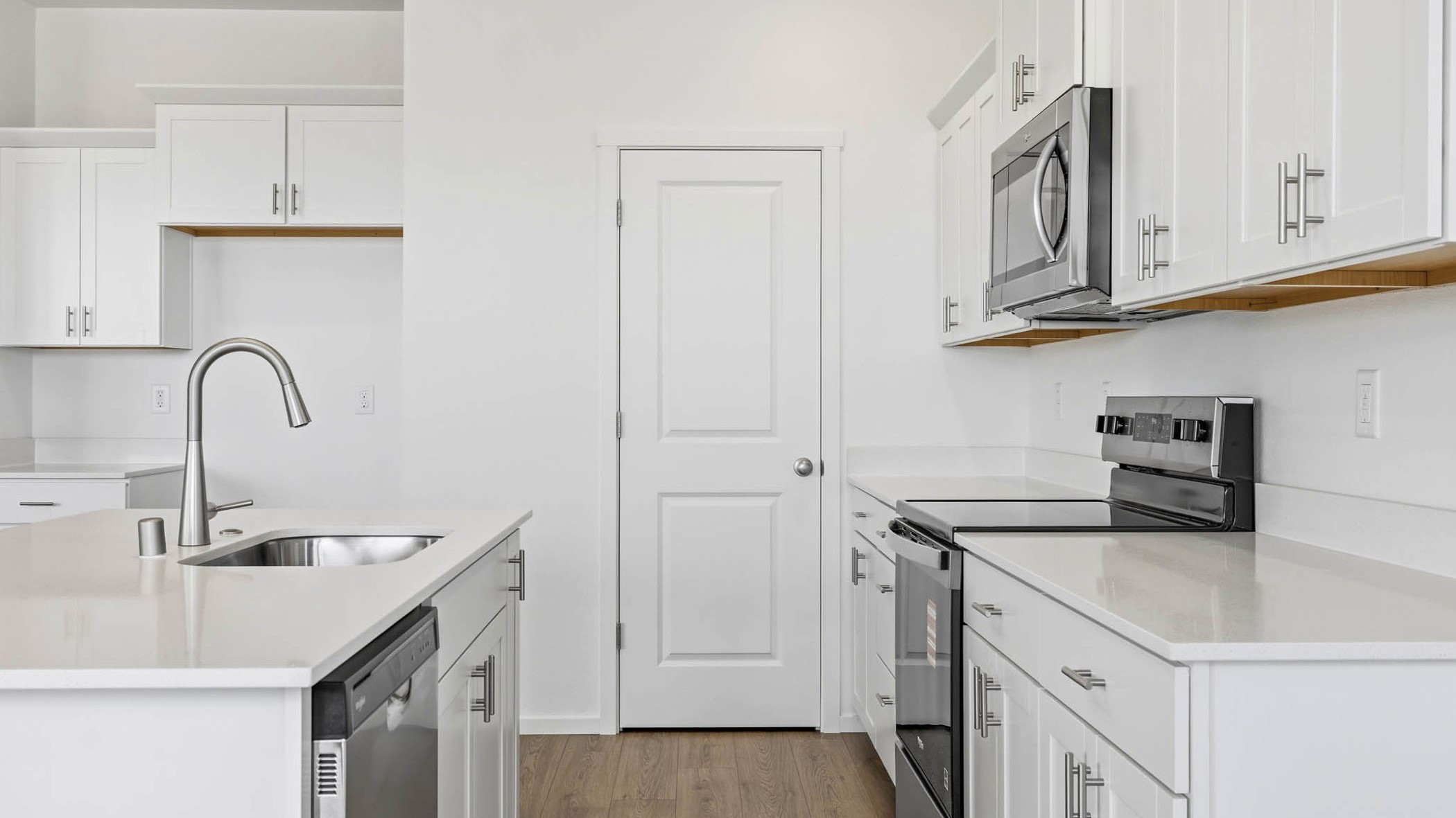 Kitchen with shaker cabinets, quartz counters, stainless steel appliances, pantry, and an island with a breakfast bar
