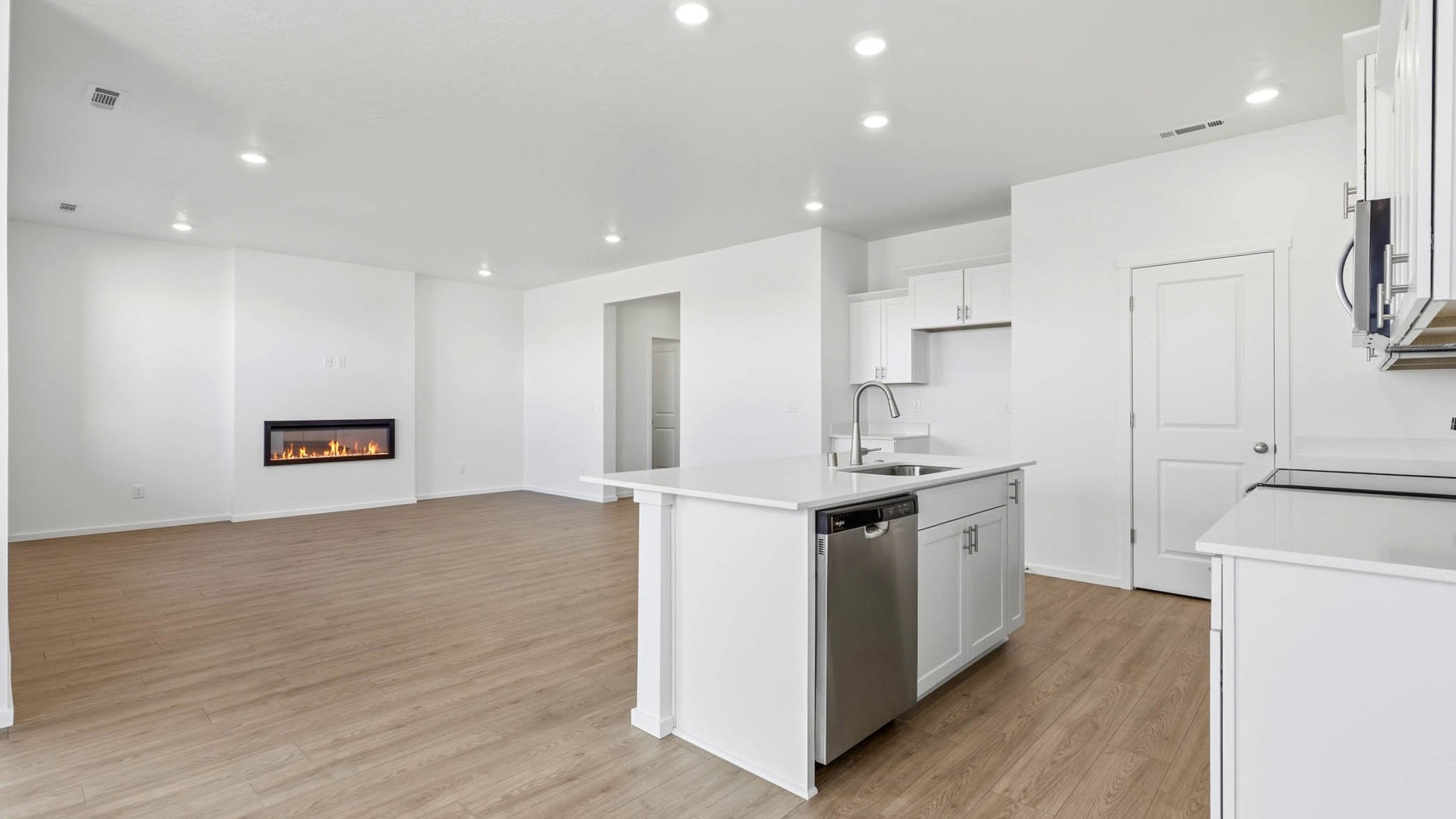 Kitchen with shaker cabinets, quartz counters, stainless steel appliances, pantry, and an island with a breakfast bar