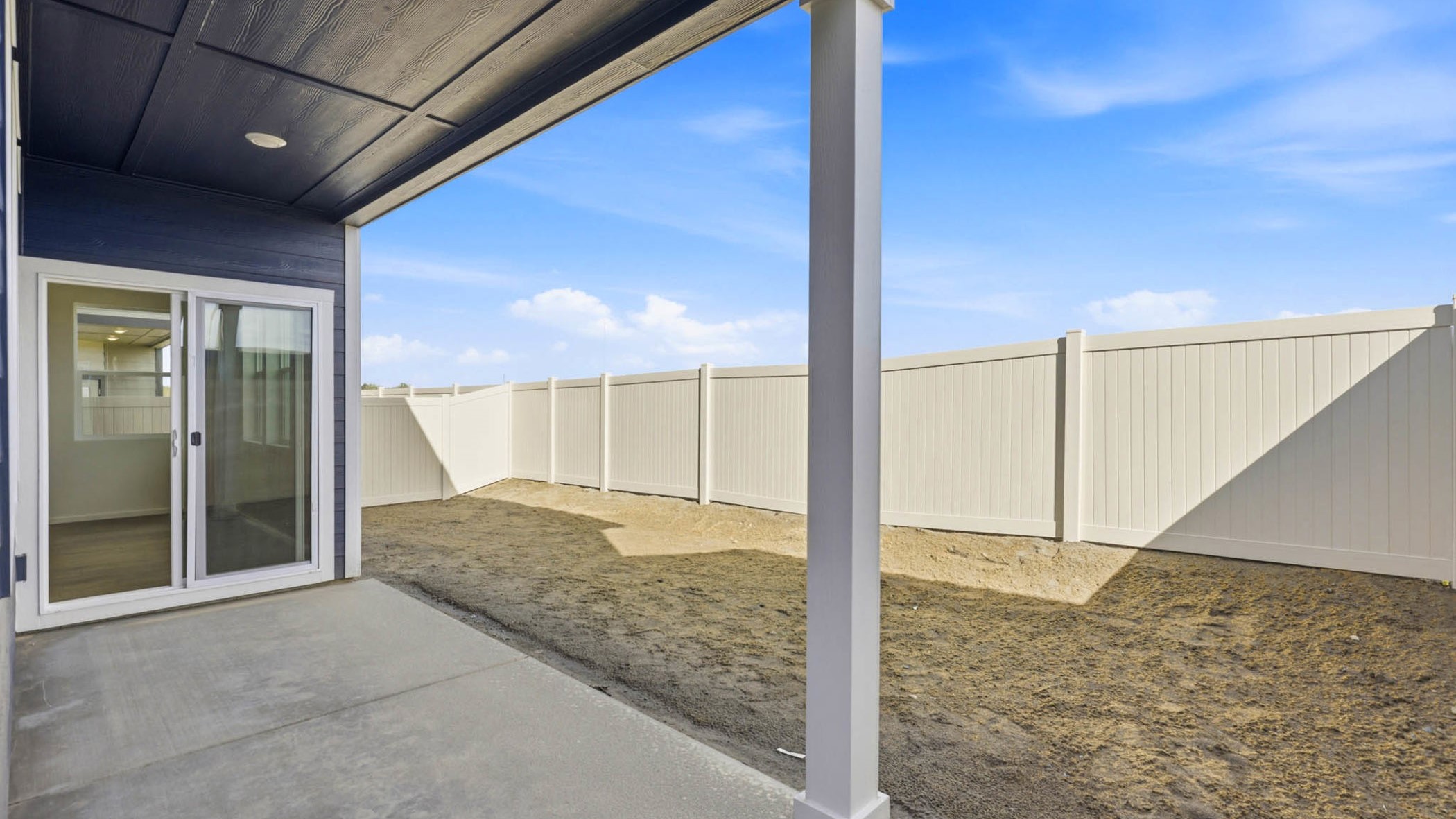 backyard with vinyl plank fence and covered patio