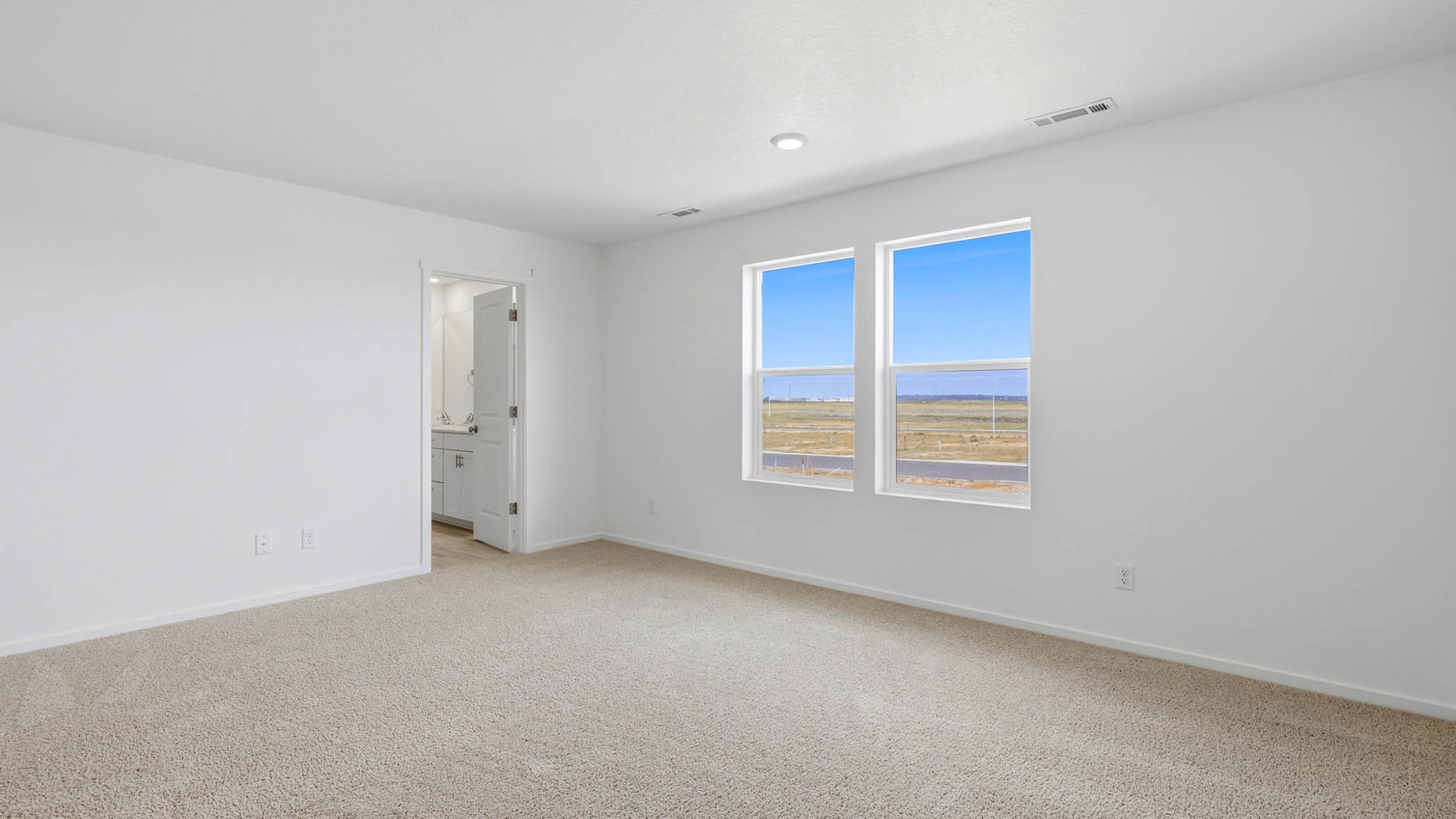 Primary bedroom with wall-to-wall carpet, a walk-in closet and an attached bathroom