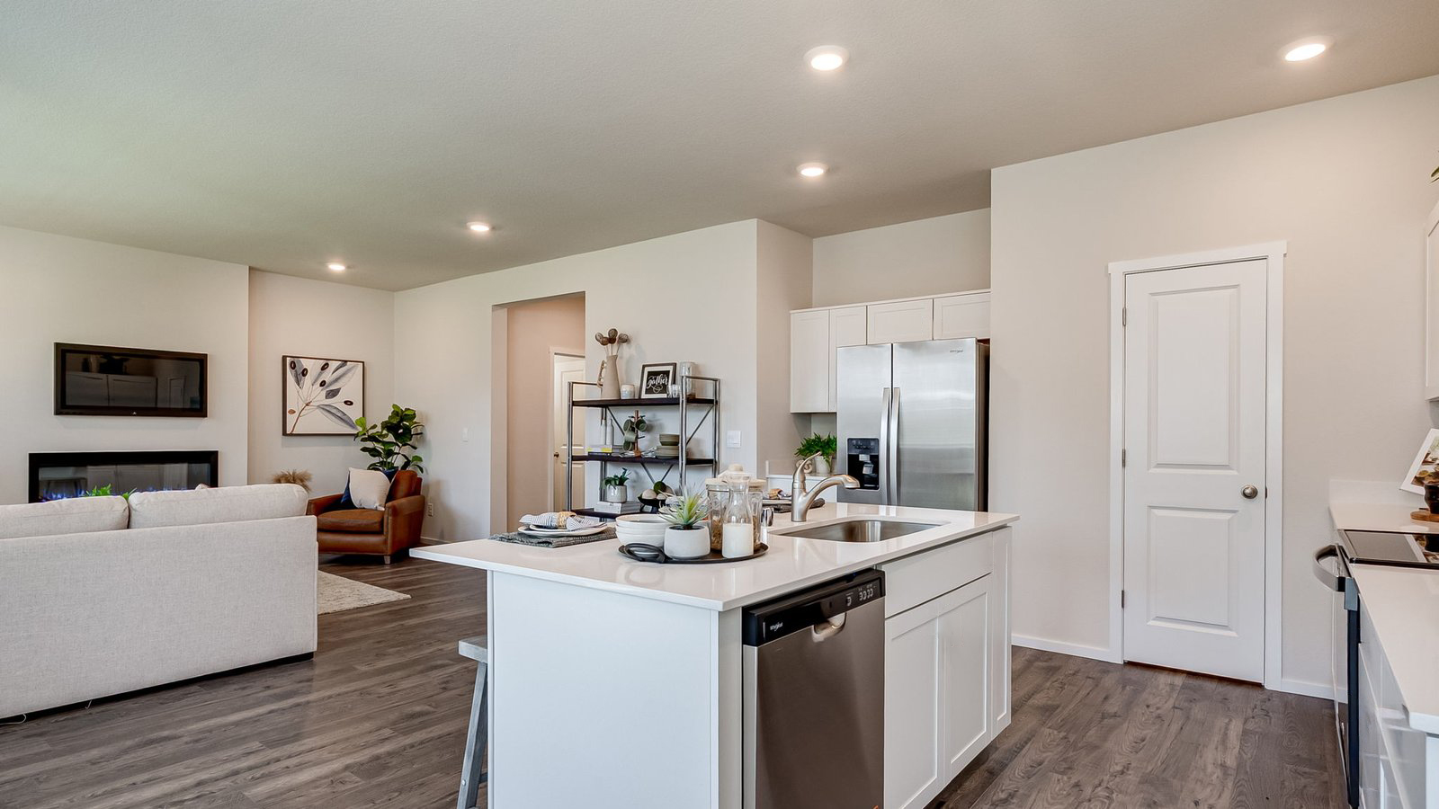 Kitchen with shaker cabinets, quartz counters, stainless steel appliances, pantry, and an island with a breakfast bar