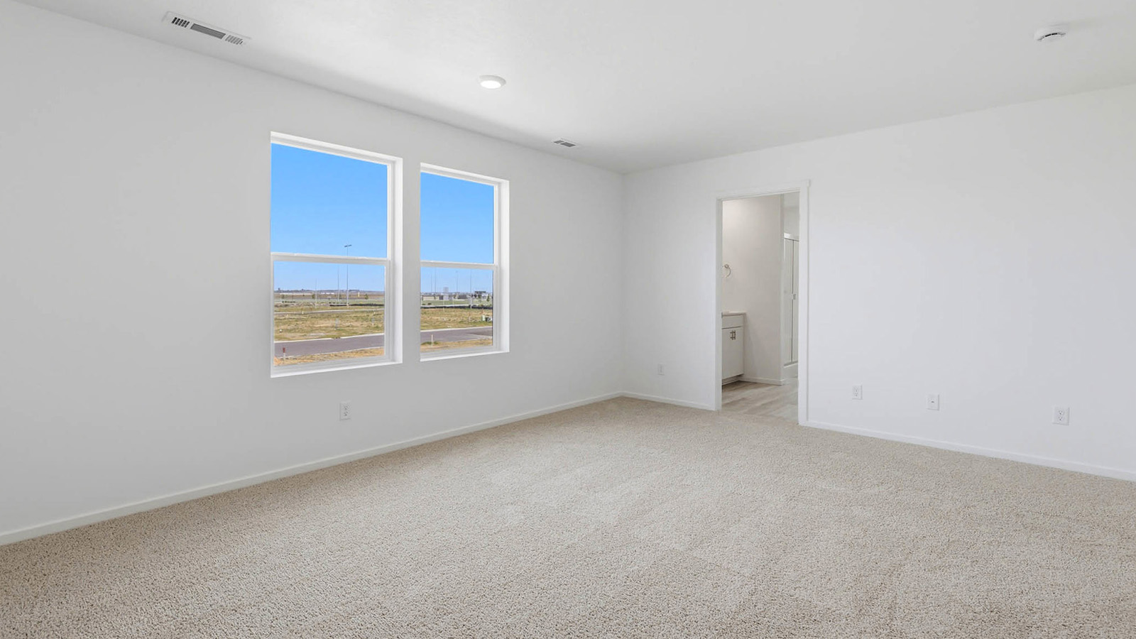 Primary bedroom with wall-to-wall carpet, a walk-in closet and an attached bathroom