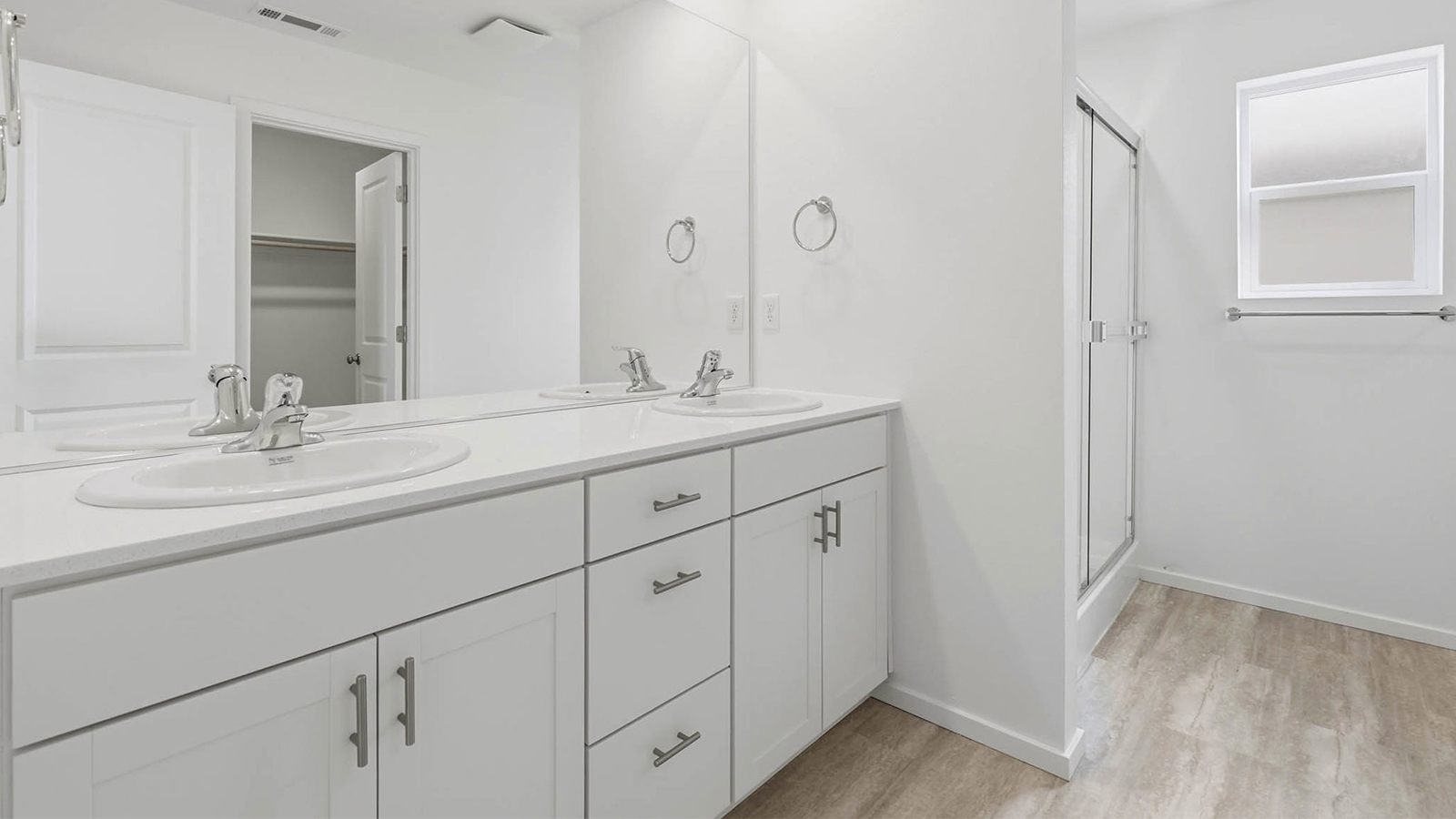 Primary bathroom with quartz counters and a walk-in shower