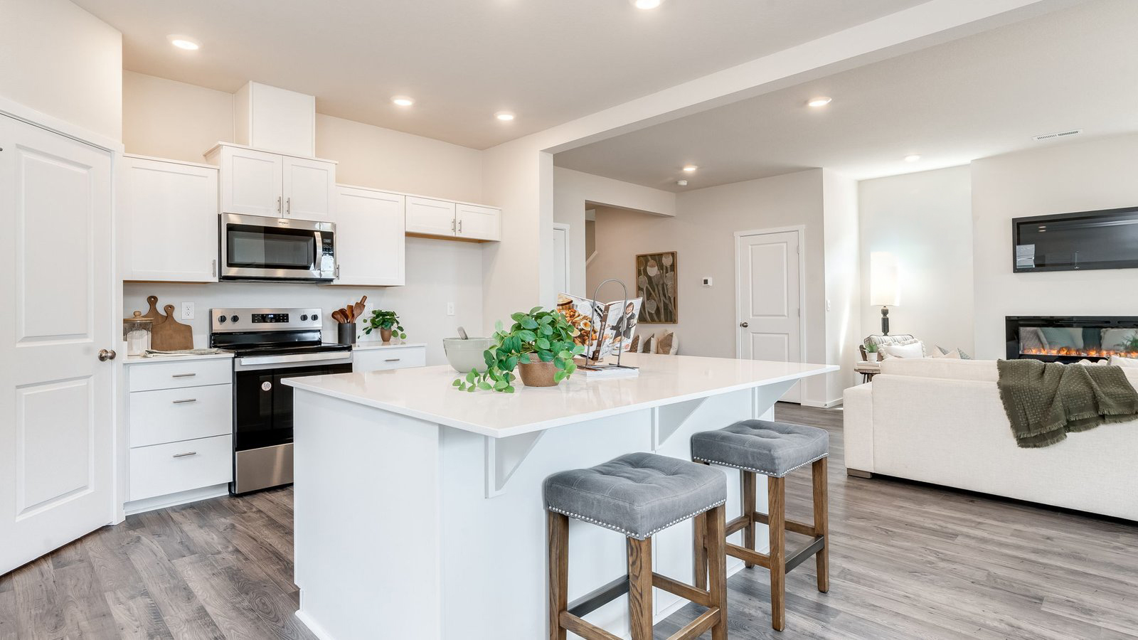 Kitchen with shaker cabinets, quartz counters, stainless steel appliances, pantry, and an island with a breakfast bar
