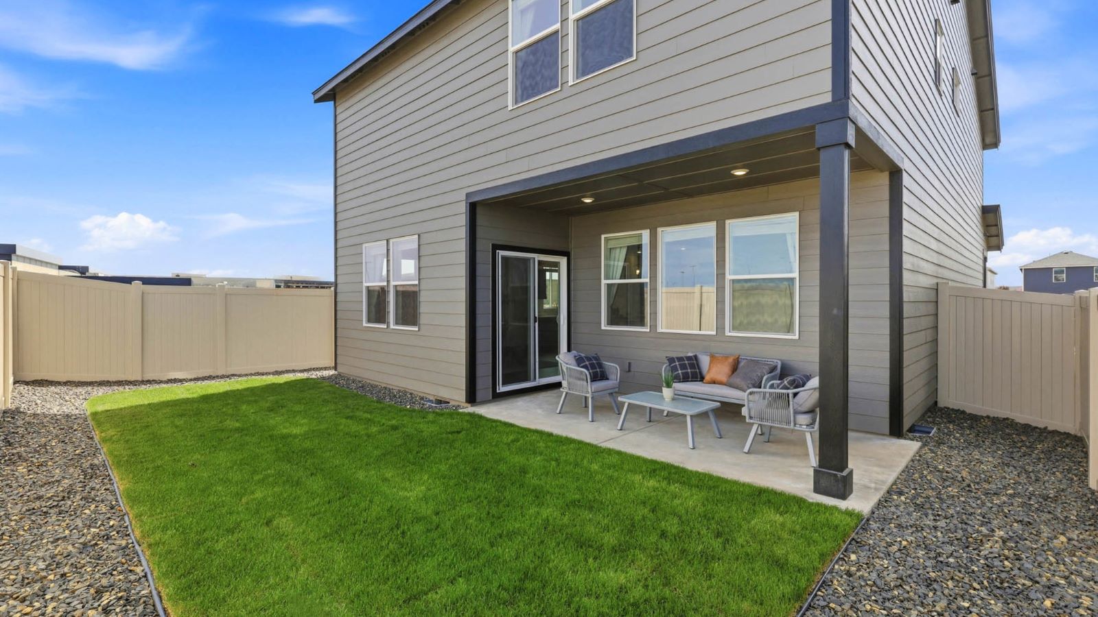 backyard with sod and vinyl plank fence and covered patio