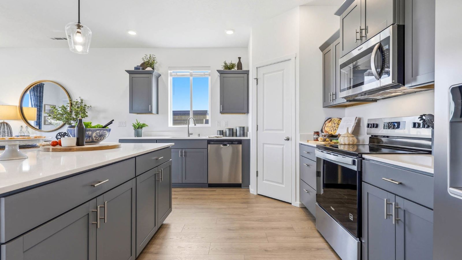 Kitchen with shaker cabinets, quartz counters, stainless steel appliances, pantry, and an island with a breakfast bar