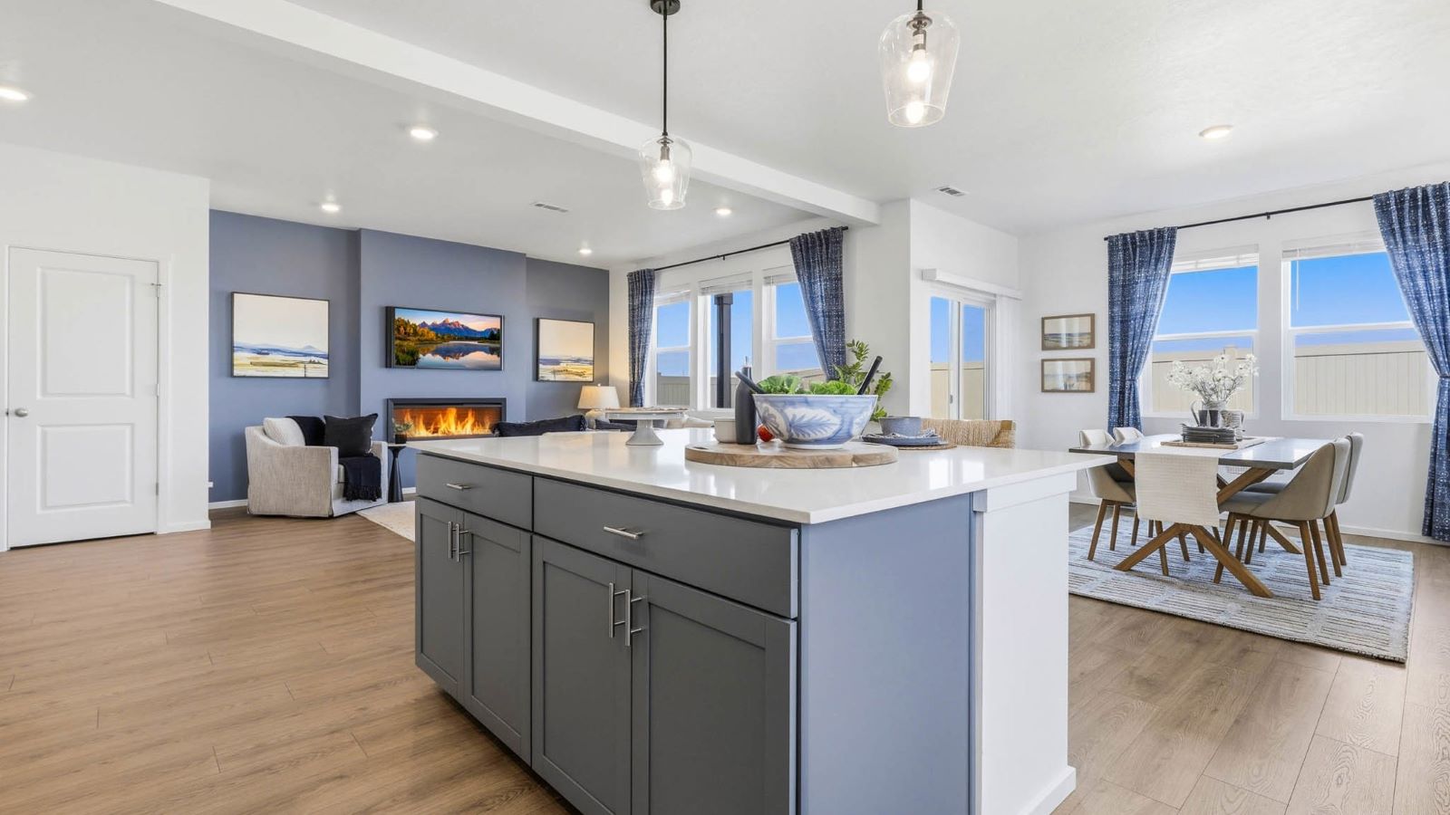 Kitchen with shaker cabinets, quartz counters, stainless steel appliances, pantry, and an island with a breakfast bar