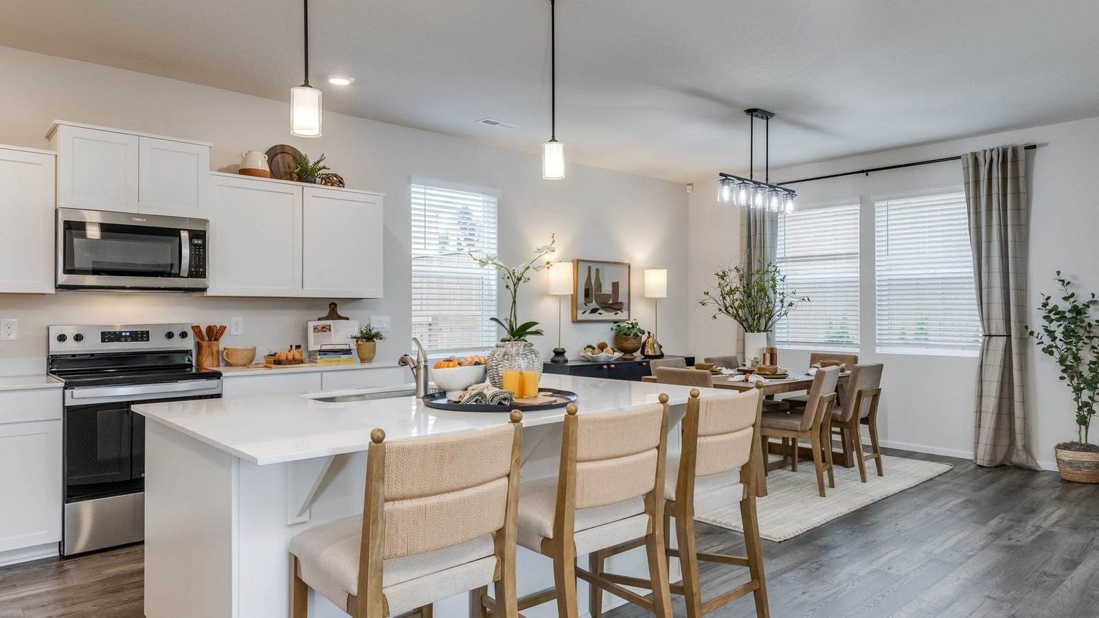 Kitchen with shaker cabinets, quartz counters, stainless steel appliances, pantry, and an island with a breakfast bar