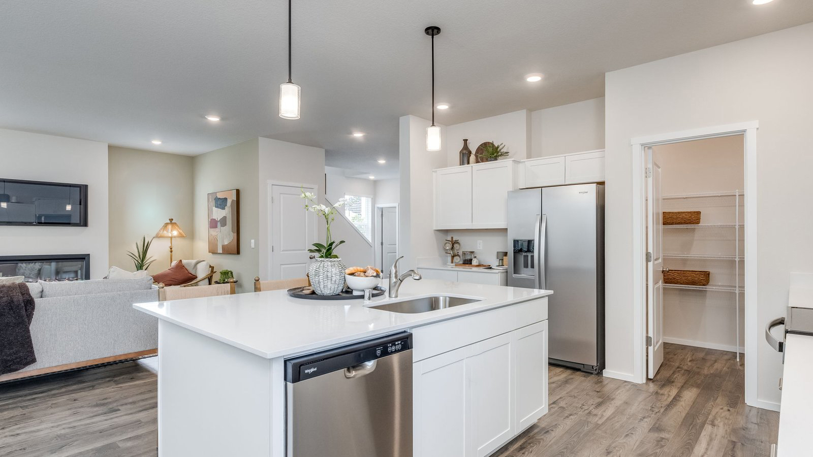 Kitchen with shaker cabinets, quartz counters, stainless steel appliances, pantry, and an island with a breakfast bar