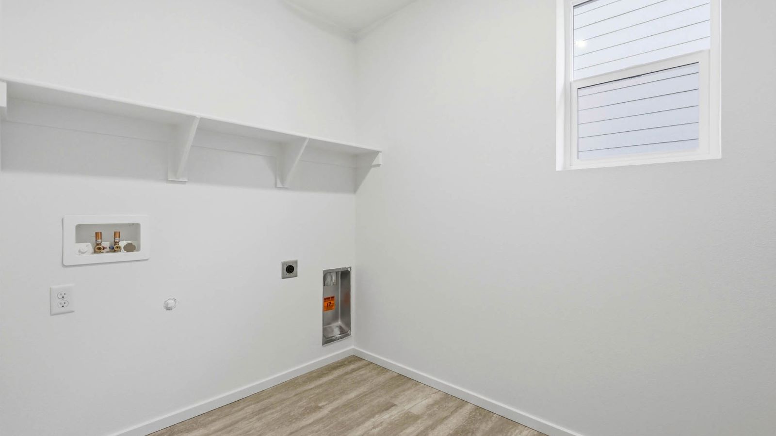 Laundry room with built-in shelves and washer and dryer hookups