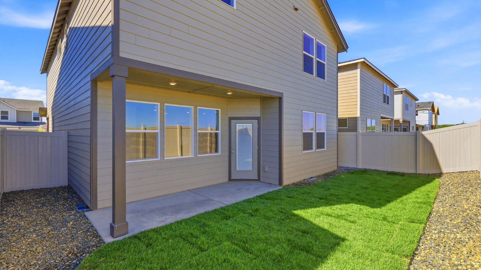 backyard with sod and vinyl plank fence and covered patio