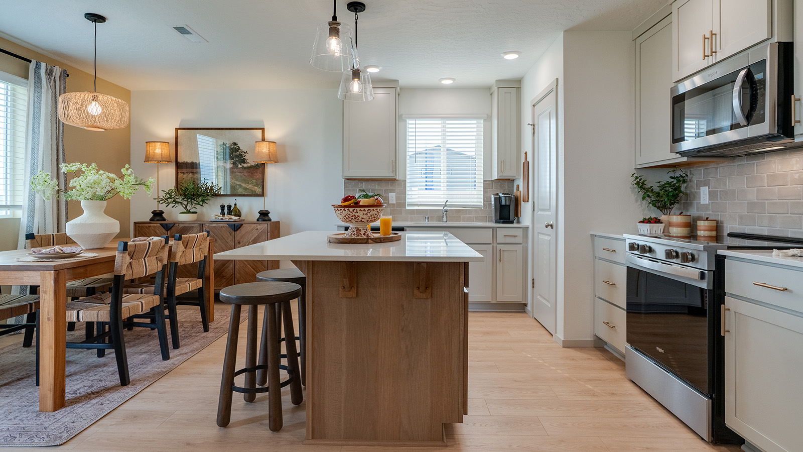 Kitchen with shaker cabinets, quartz counters, stainless steel appliances, pantry, and an island with a breakfast bar
