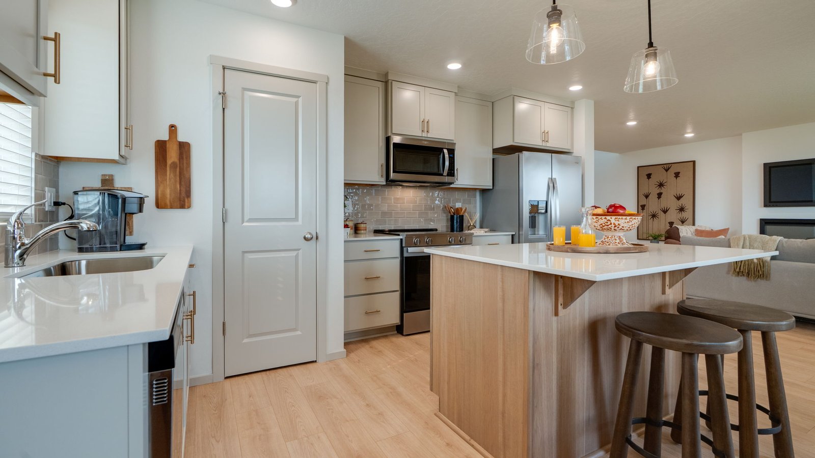 Kitchen with shaker cabinets, quartz counters, stainless steel appliances, pantry, and an island with a breakfast bar