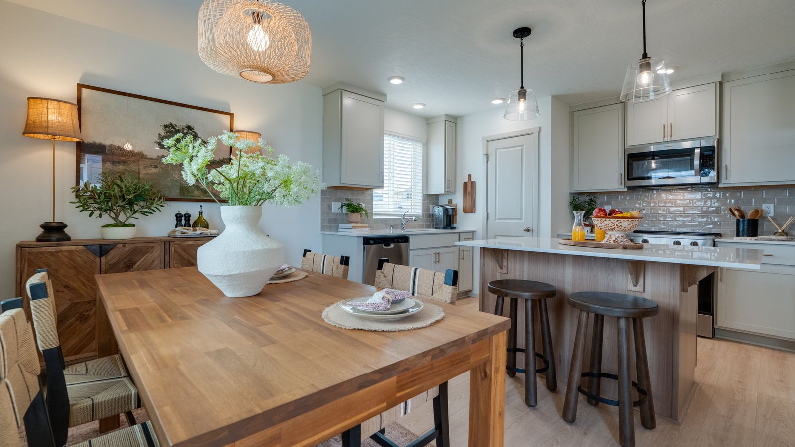 Kitchen with shaker cabinets, quartz counters, stainless steel appliances, pantry, and an island with a breakfast bar