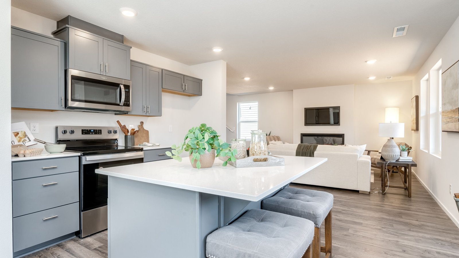 Kitchen with shaker cabinets, quartz counters, stainless steel appliances, pantry, and an island with a breakfast bar