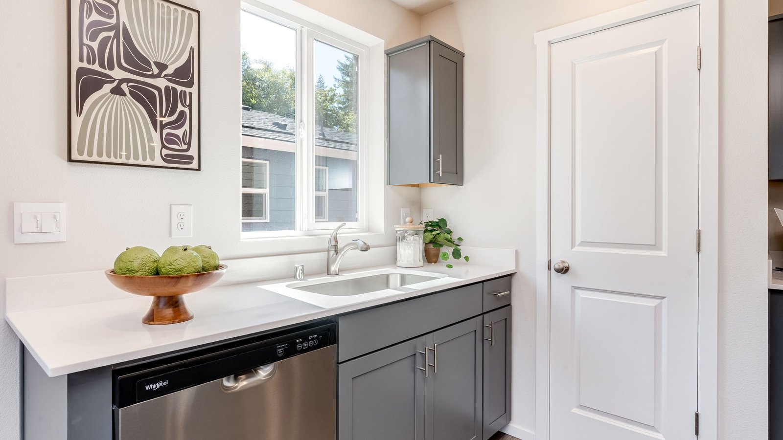 Kitchen with shaker cabinets, quartz counters, stainless steel appliances, pantry, and an island with a breakfast bar