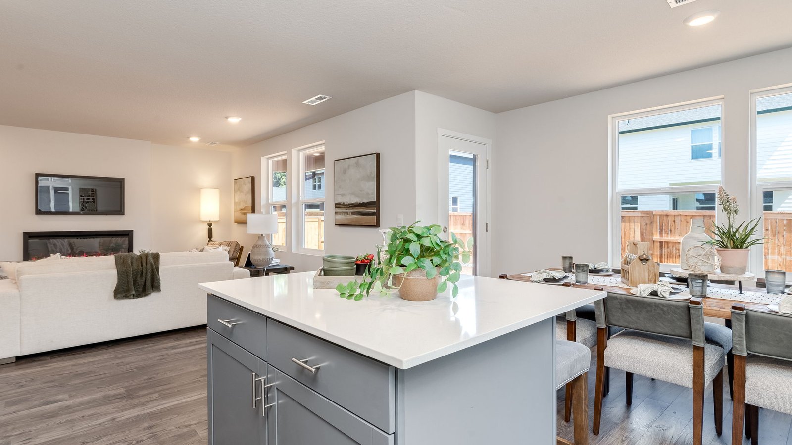 Kitchen with shaker cabinets, quartz counters, stainless steel appliances, pantry, and an island with a breakfast bar