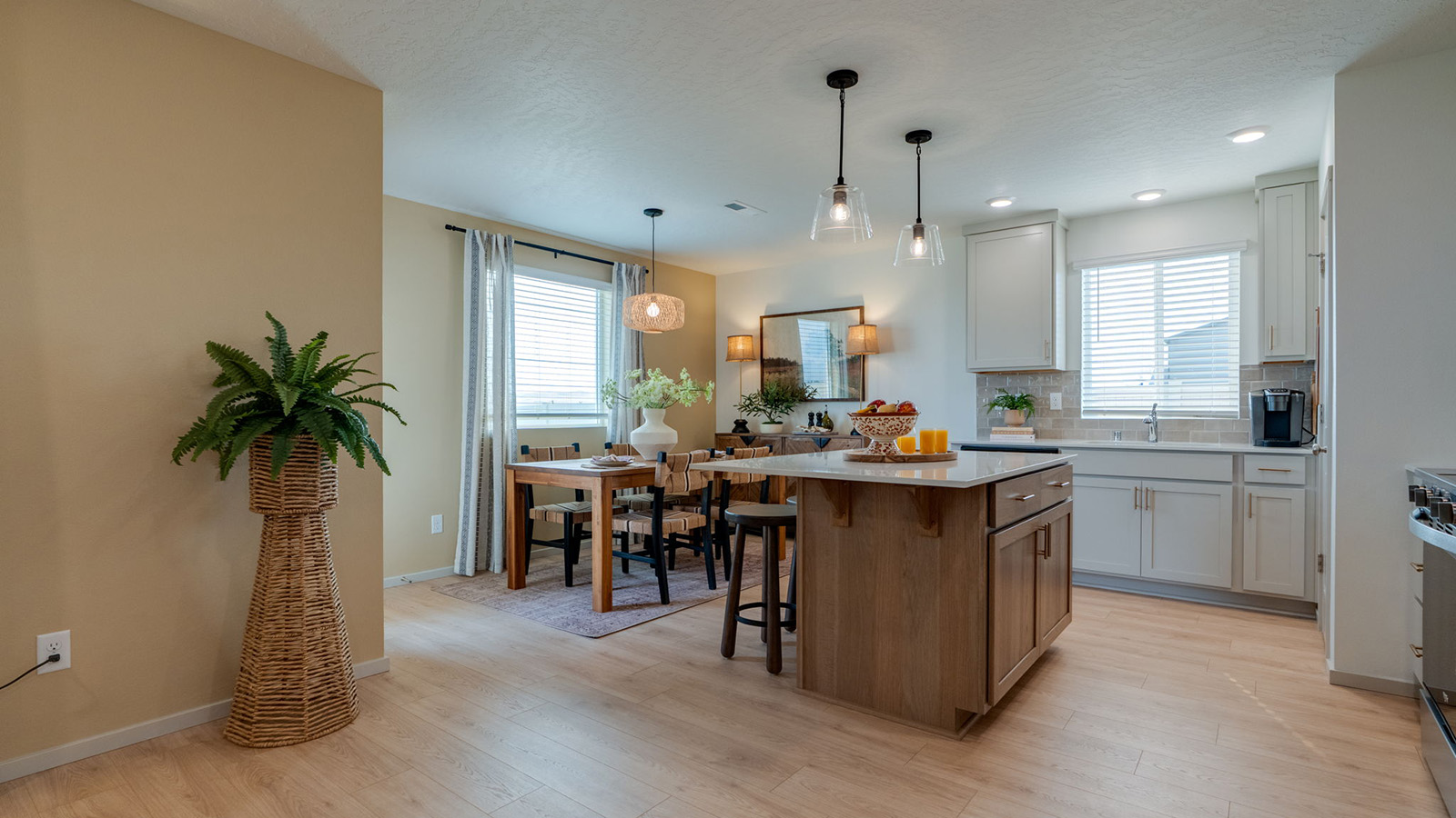 Kitchen with shaker cabinets, quartz counters, stainless steel appliances, pantry, and an island with a breakfast bar