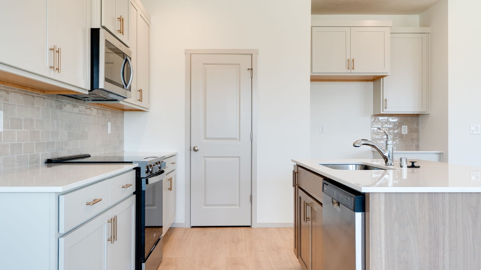 Kitchen with shaker cabinets, quartz counters, stainless steel appliances, pantry, and an island with a breakfast bar