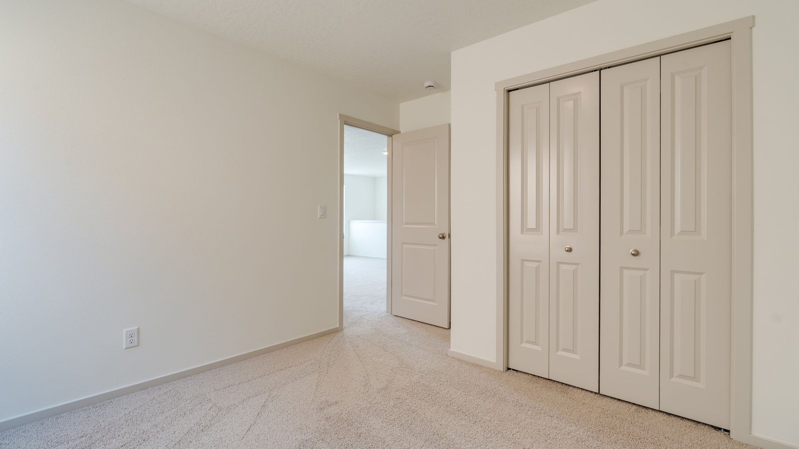 Bedroom with wall-to-wall carpet and a closet