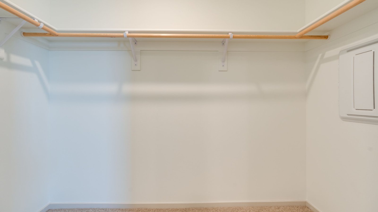 Primary bedroom walk-in closet with built-in shelves