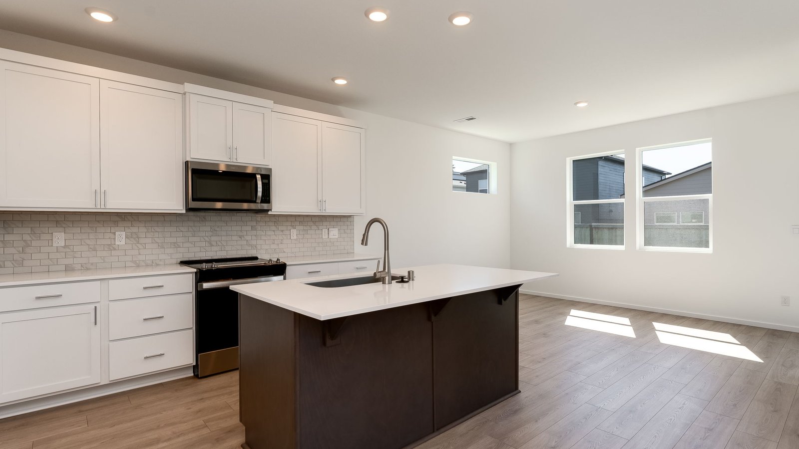 Kitchen with shaker cabinets, quartz counters, stainless steel appliances, pantry, and an island with a breakfast bar