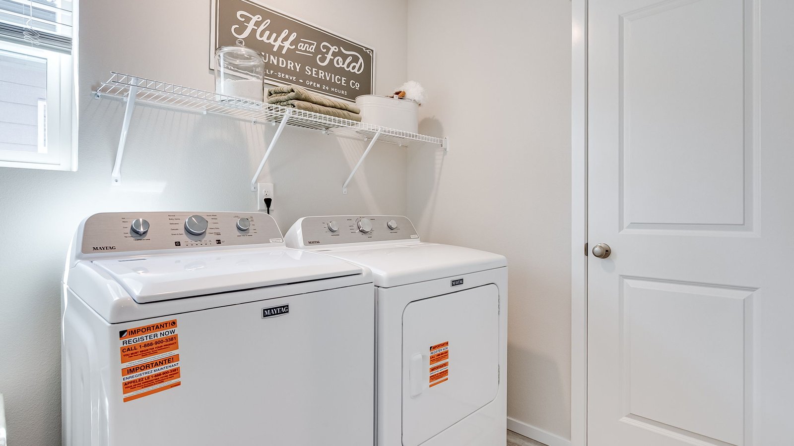 Laundry room with built-in shelves and washer and dryer hookups