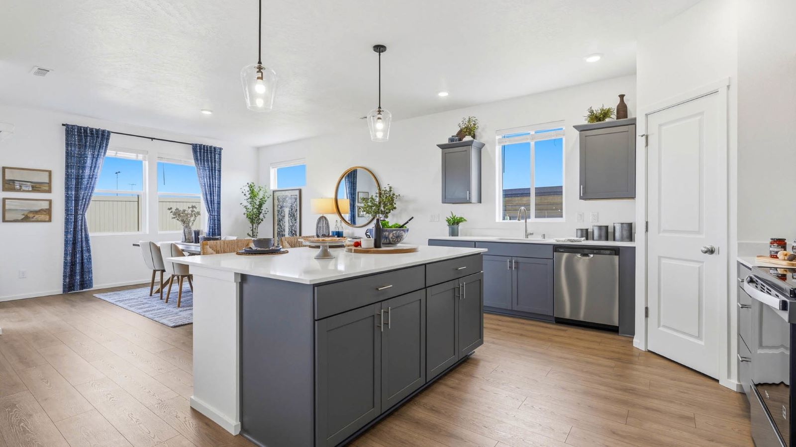 Kitchen with shaker cabinets, quartz counters, stainless steel appliances, pantry, and an island with a breakfast bar