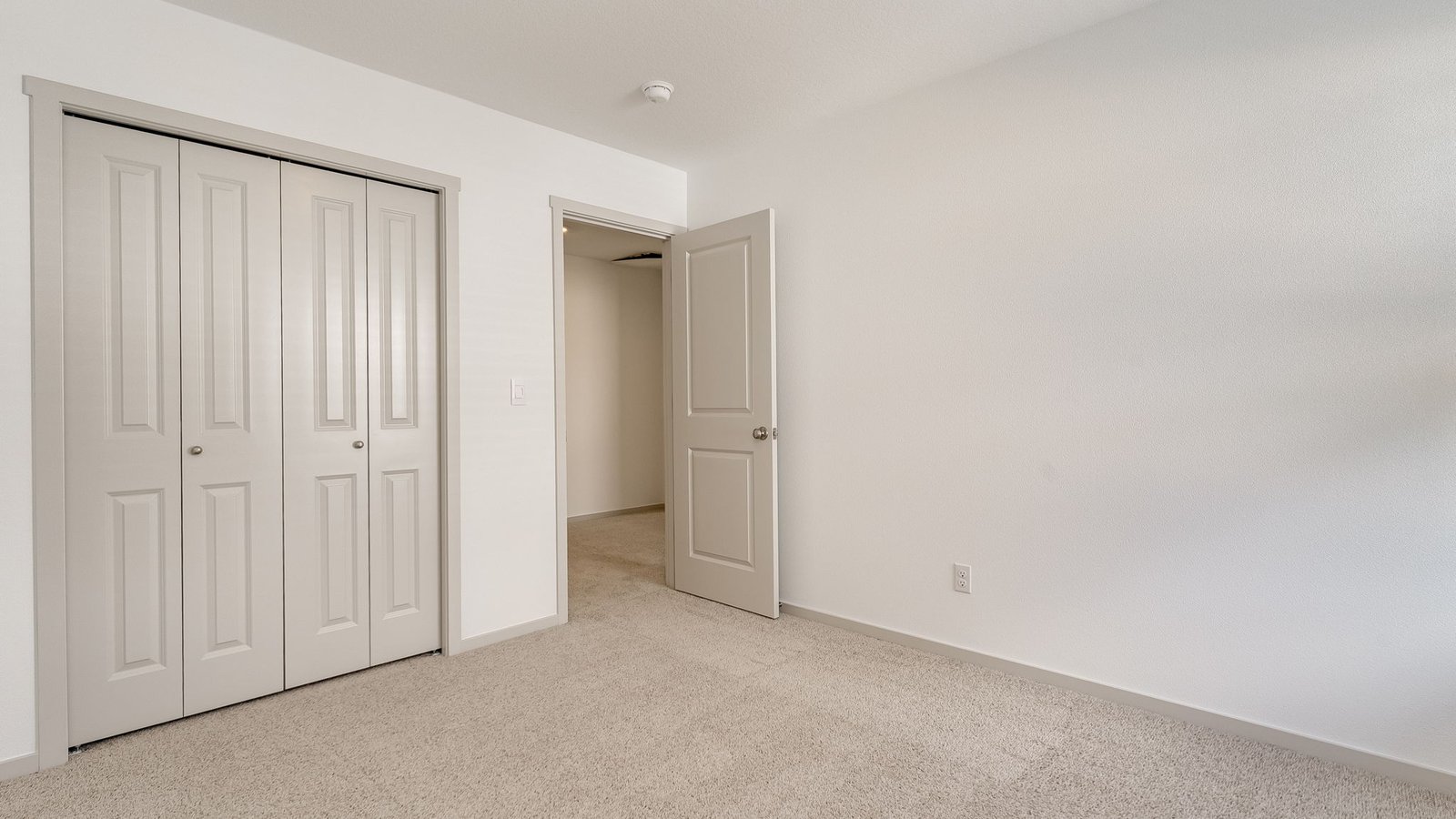 Bedroom with wall-to-wall carpet and a closet